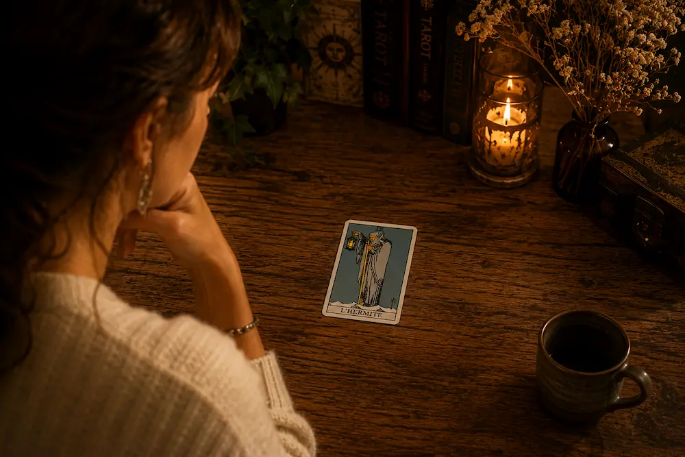 Personne observant une seule carte de Tarot sans consulter de livret afin de développer sa lecture intuitive.